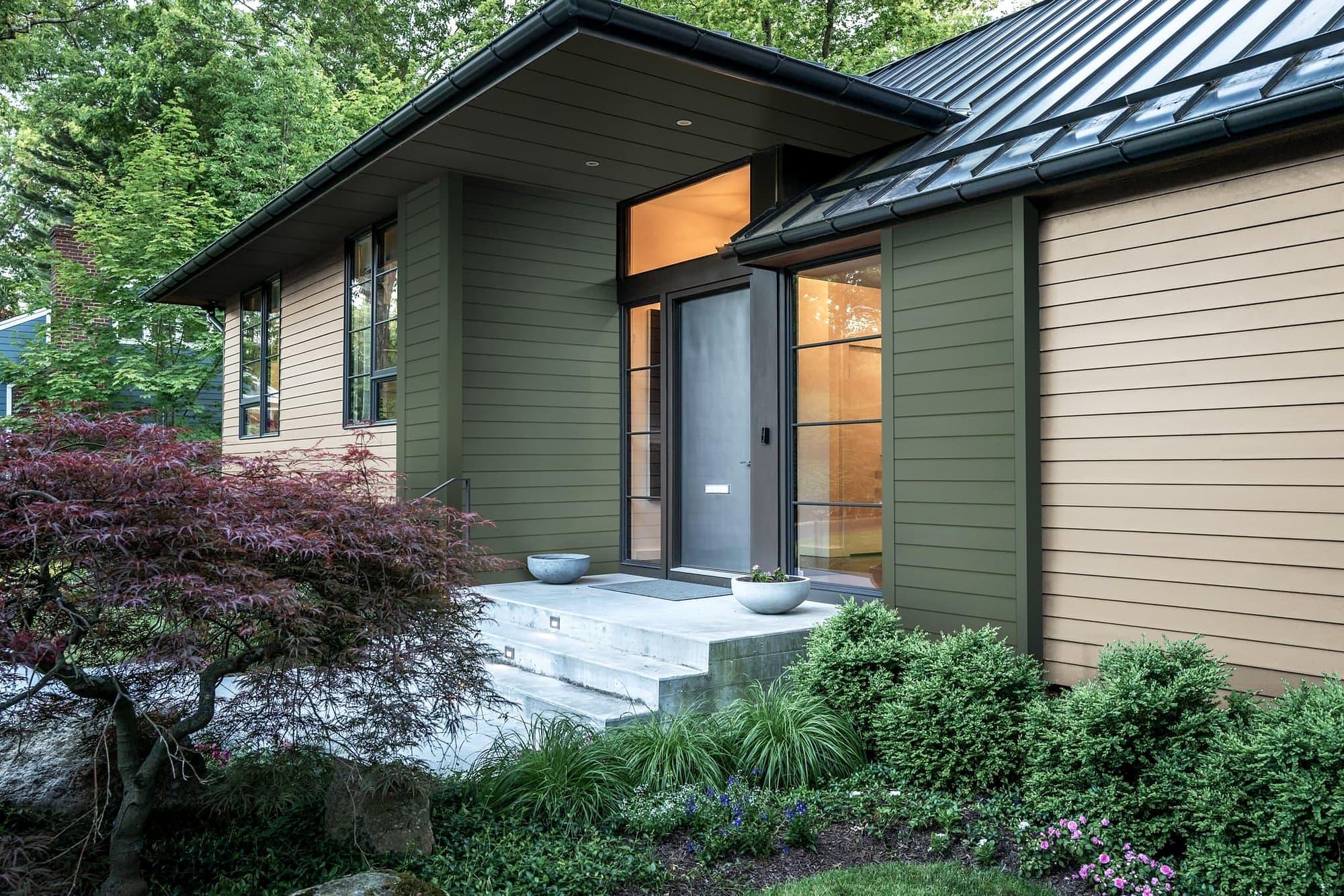 Modern home with dark green James Hardie fiber cement siding and dark roof