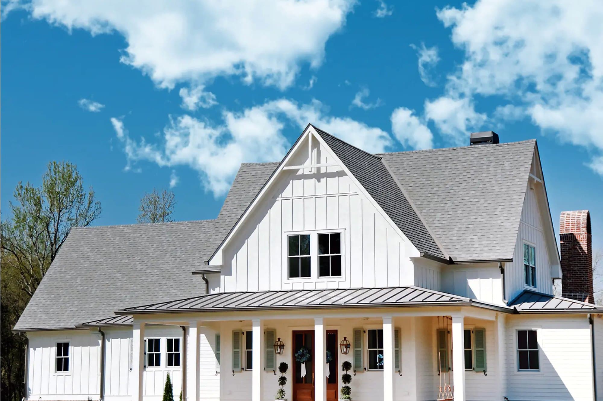 White farmhouse with new black-framed windows and a covered porch in the Portland area