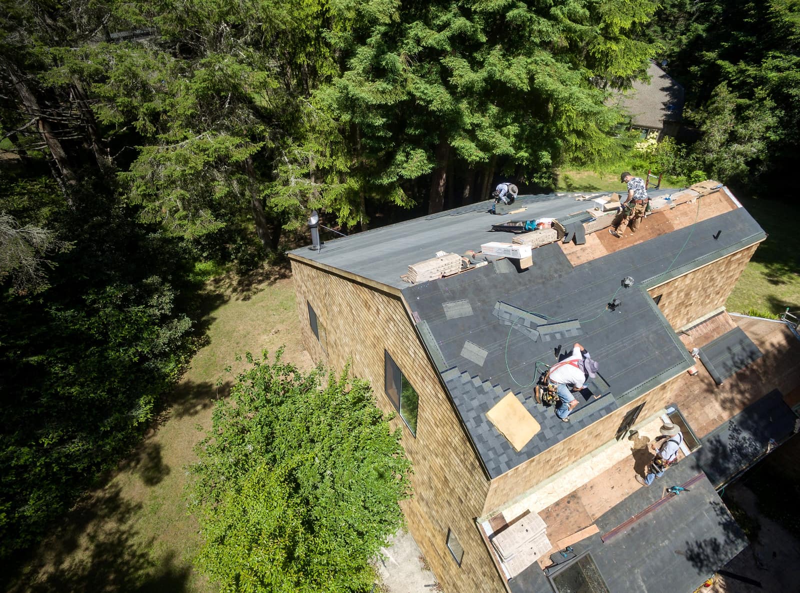 Aerial view of a crew installing a new architectural shingle roof on a Portland home
