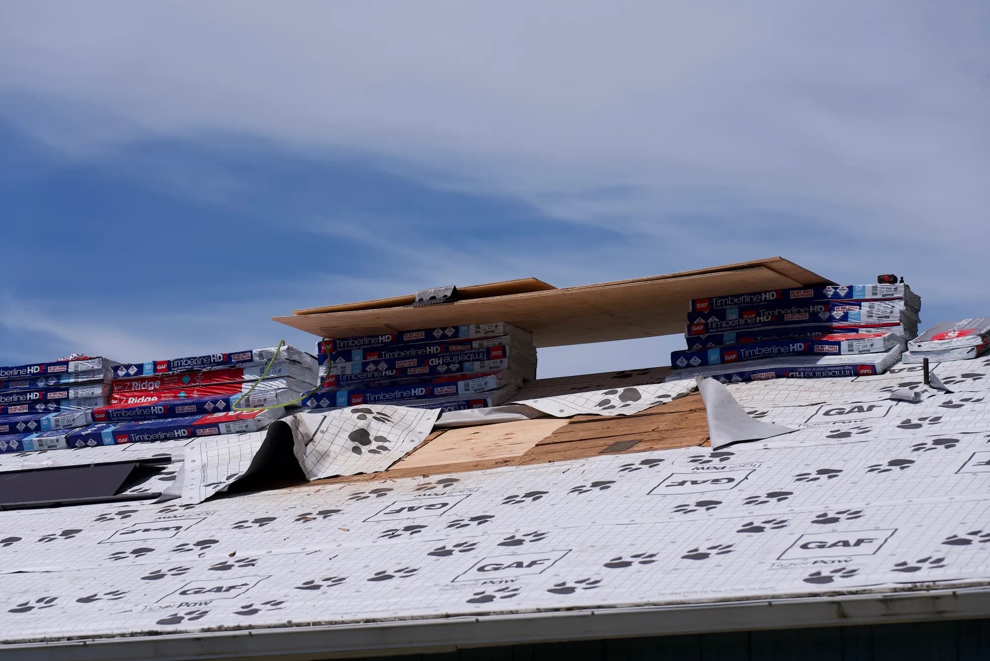 Wide view of a roof covered in GAF Tiger Paw underlayment with shingle bundles staged at the ridge in Hillsboro, OR