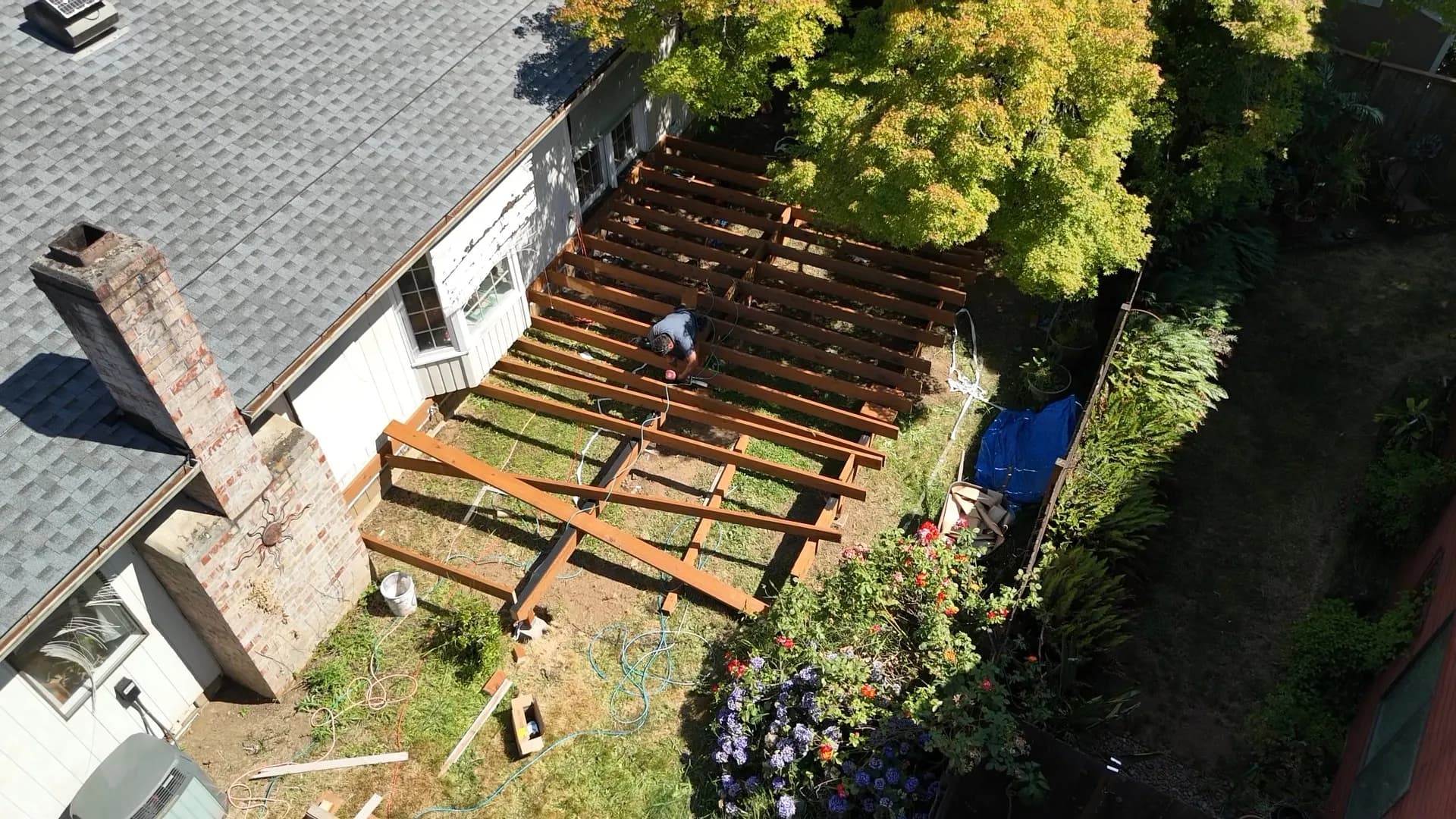 Aerial view of pressure-treated deck joists being framed behind a house in Tualatin, OR
