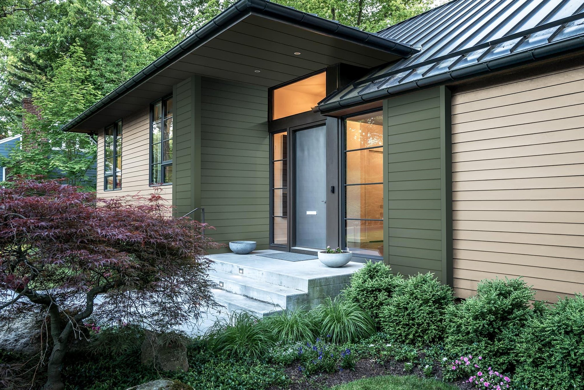 Modern home with dark green James Hardie fiber cement siding and dark roof