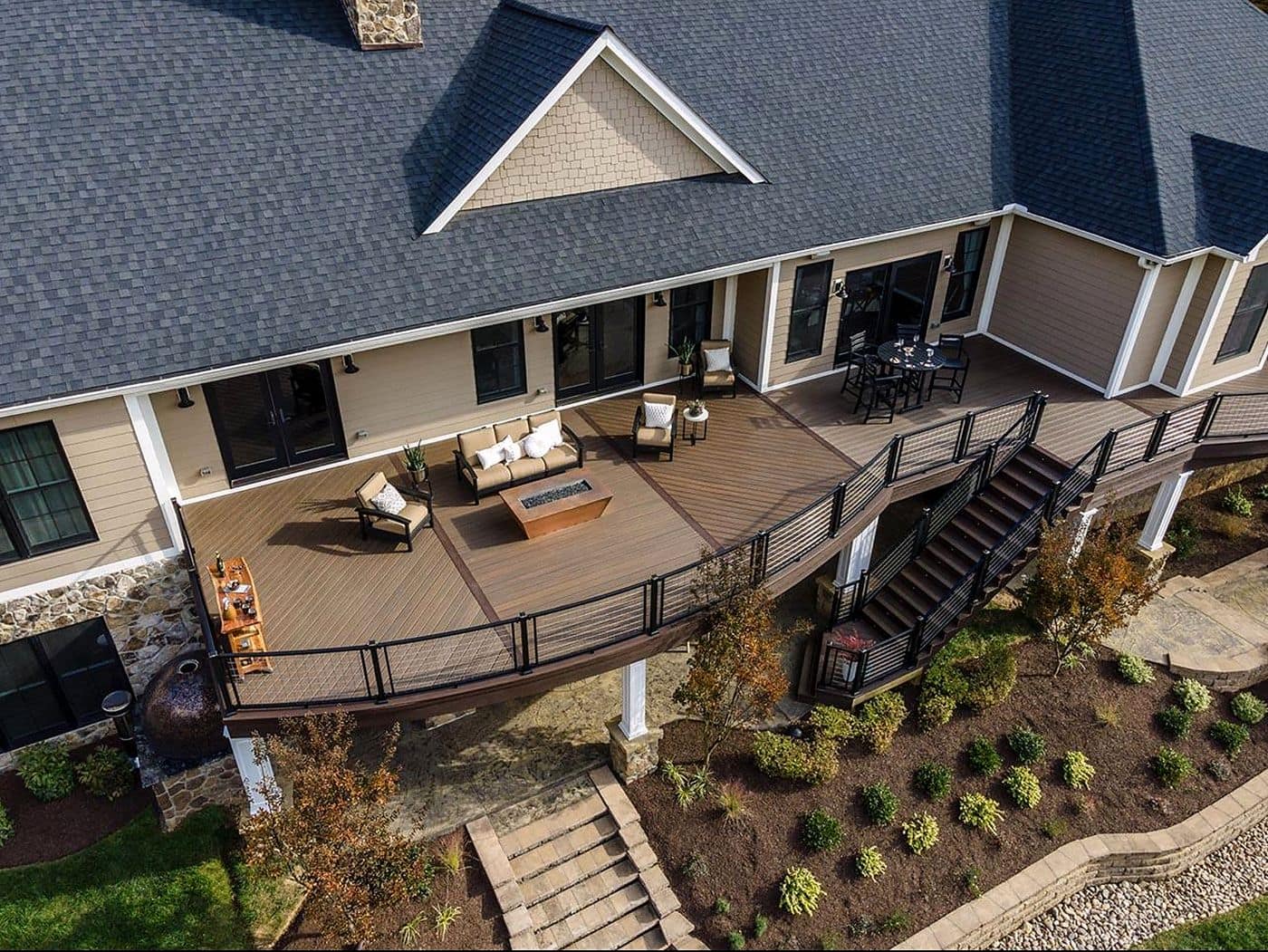 Backyard deck with cable railings and outdoor seating on a renovated home