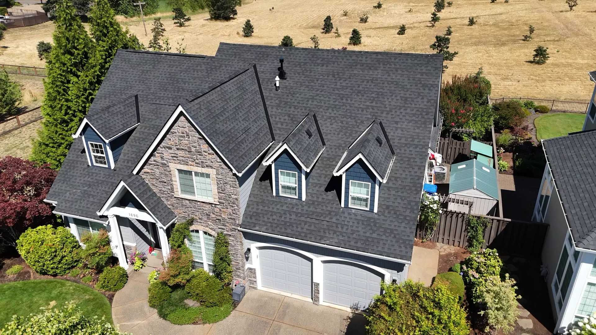 Aerial view of a completed charcoal shingle roof on a two-story Salem, OR home